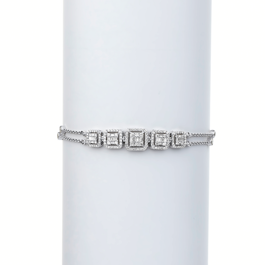 A tennis bracelet featuring natural diamonds set in 18 karat gold, displayed on a white cylindrical stand.