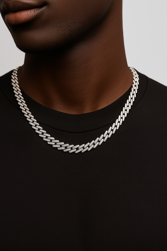 Person wearing a silver chain necklace on a plain background