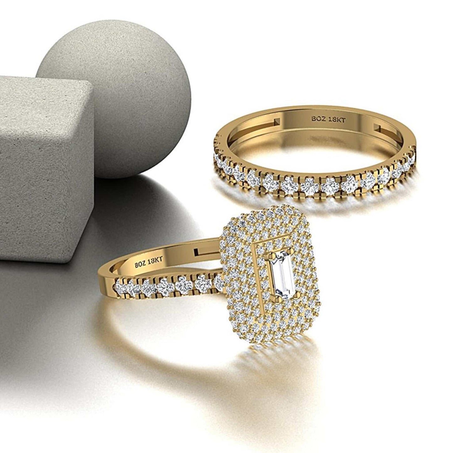 Two gold rings with diamond accents on a light background