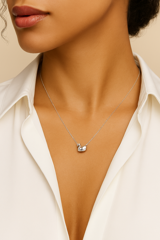 Necklace with a small pendant worn by a person against a neutral background