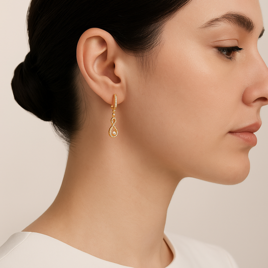 Close-up of a woman wearing gold earrings on a beige background