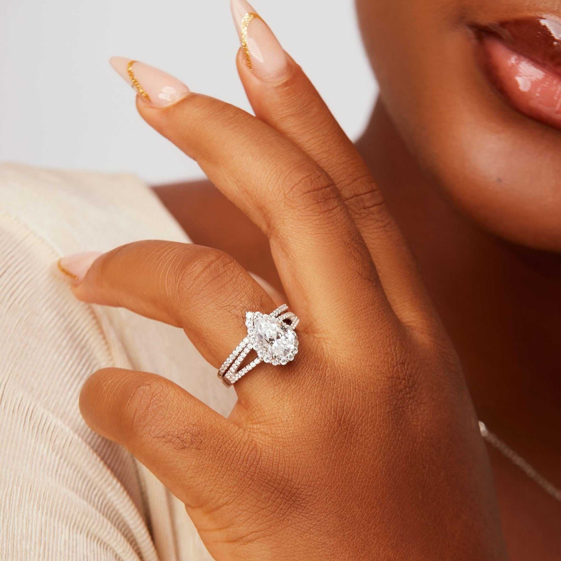 Aurora Pear Cut CZ sterling silver bridal ring set on hand with pear-shaped cubic zirconia centerpiece and halo design