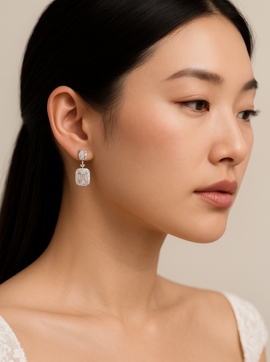 Woman wearing diamond earrings with a neutral background