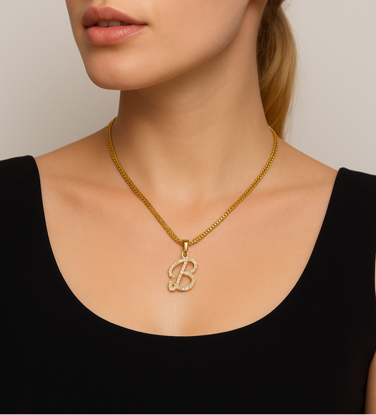 Woman wearing a gold necklace with a 'B' pendant against a neutral background