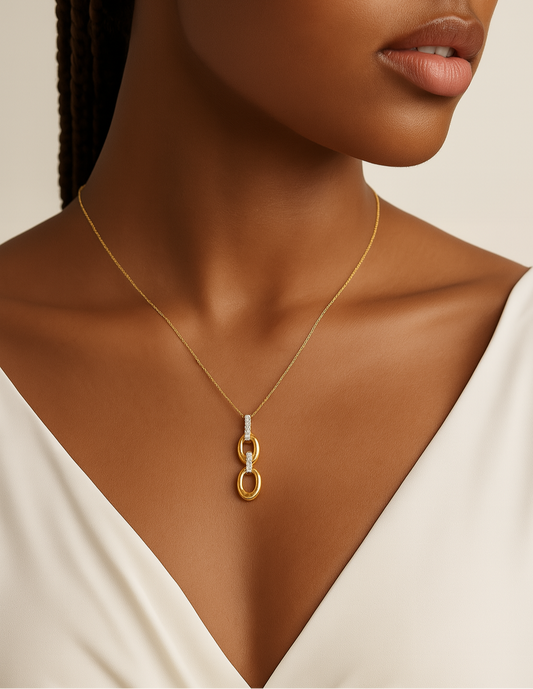 Woman wearing a gold necklace with a minimalistic pendant on a neutral background
