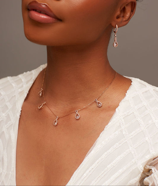 Woman wearing a delicate necklace with a neutral background