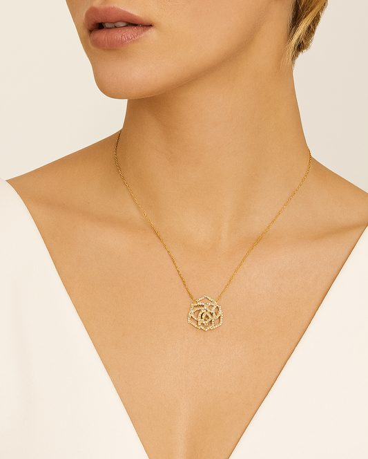 Gold necklace with a rose pendant on a mannequin neck against a beige background