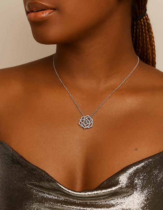 Woman wearing a silver necklace with a floral pendant against a neutral background